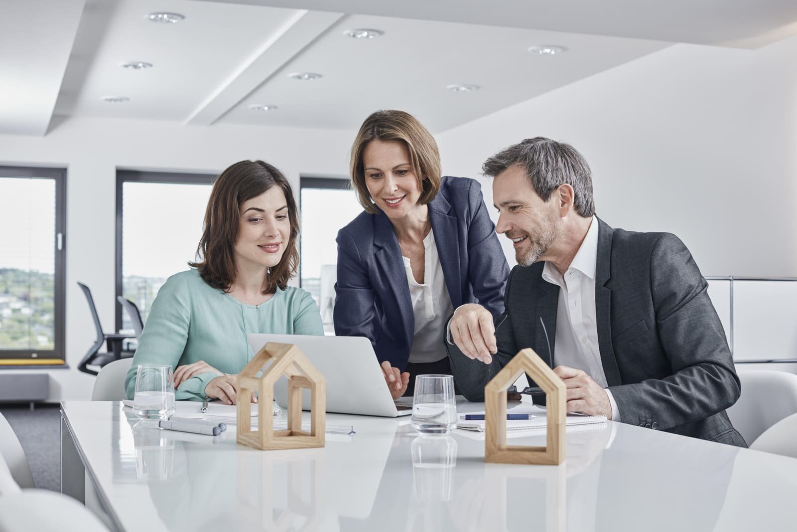 Advisors reviewing a property portfolio with model houses on the table